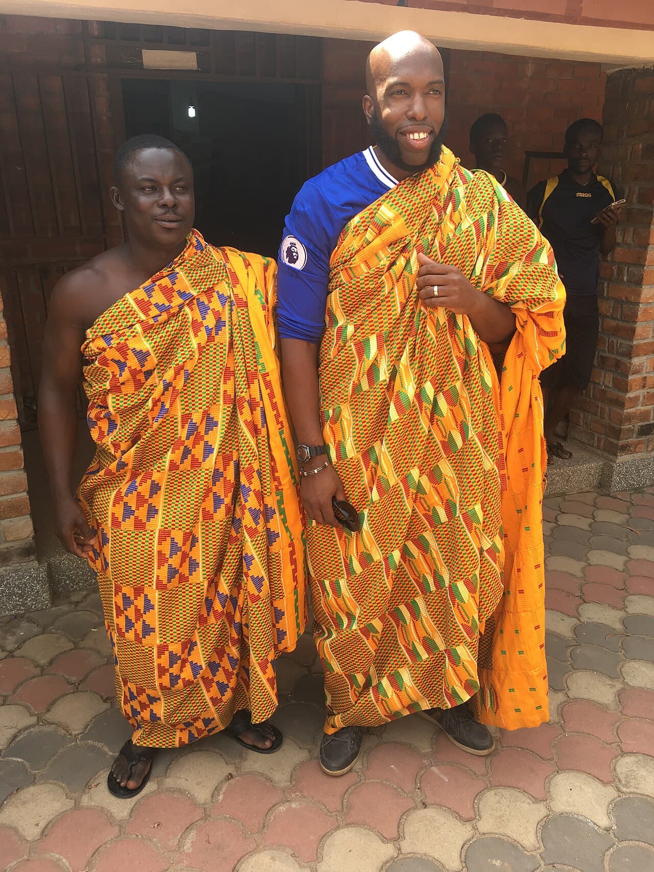 Ghanaian sellers wearing handwoven Kente cloth